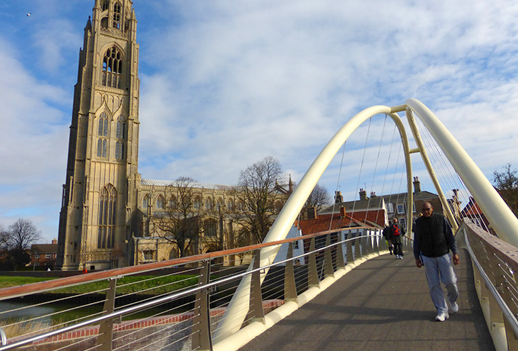 modern bridge next to historical church building